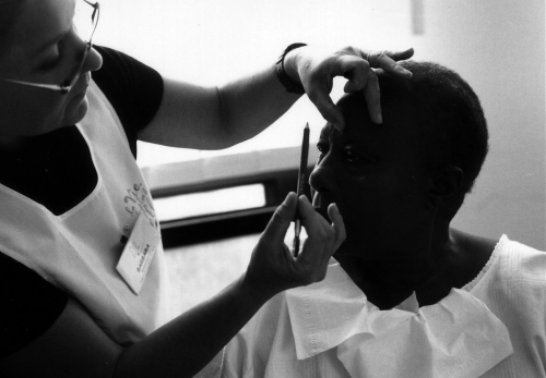 A make-up artist makes up a woman.